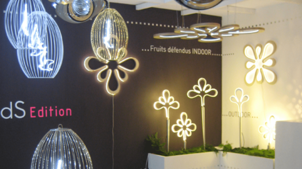 Stand de design mettant en avant des suspensions lumineuses sculpturales en verre et métal, avec des formes organiques et modernes