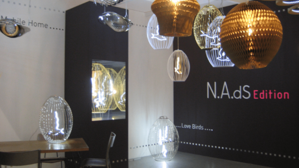 Installation lumineuse avec suspensions en métal doré et luminaires LED en forme de fleurs, créant une ambiance chaleureuse et contemporaine
