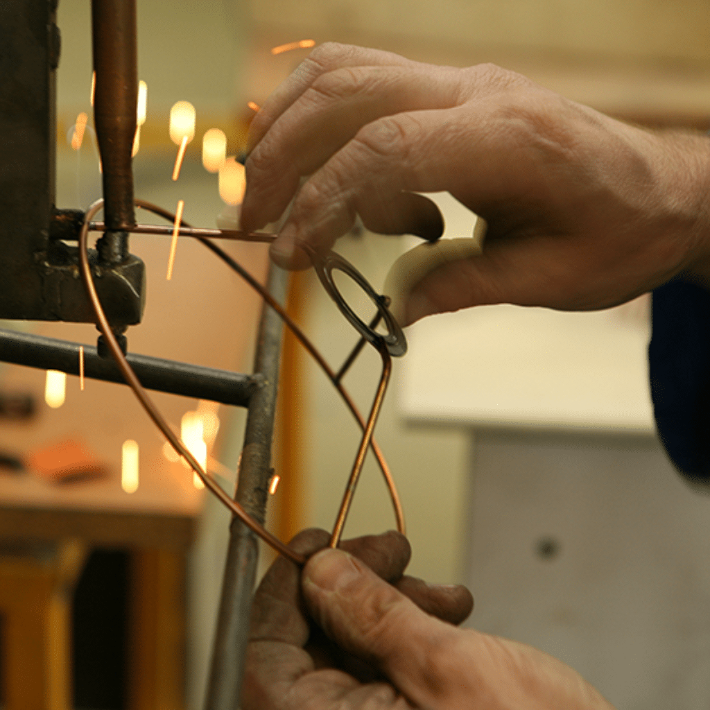 Fabrication artisanale d’une carcasse d’abat jour en fil métallique, travail du métal avec précision
