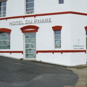 Façade de l’Hôtel du Phare avec enseigne et fenêtres encadrées de rouge