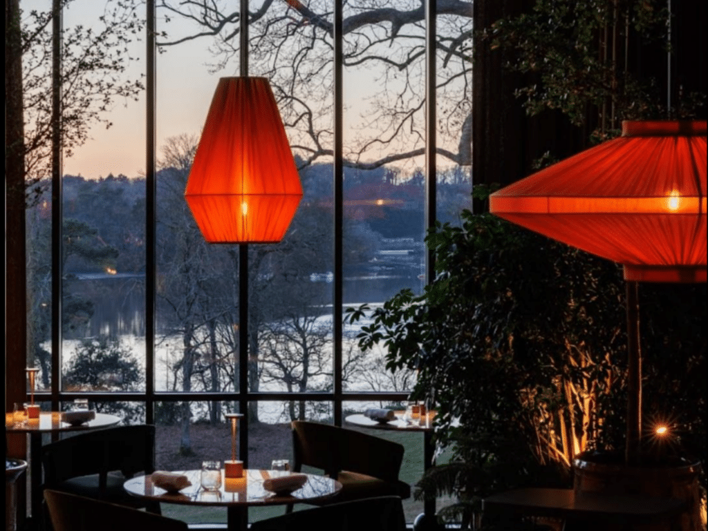 Luminaires rouges suspendus dans un restaurant avec vue panoramique au crépuscule