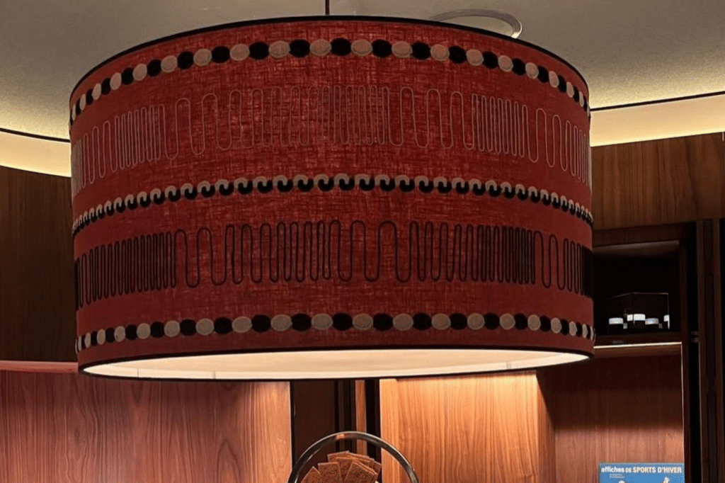 Suspension cylindrique en tissu rouge avec motifs géométriques noirs et blancs
