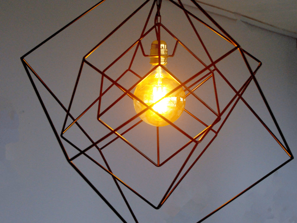 Suspension design en métal avec une ampoule à filament, encadrée par des cubes imbriqués pour un effet géométrique moderne