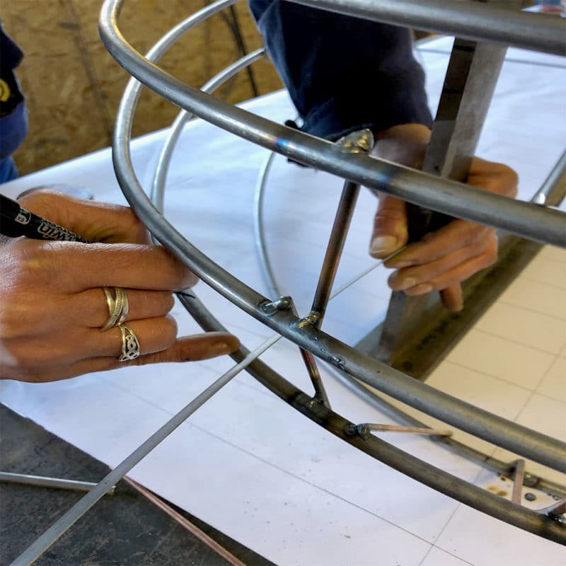 Détail d’un artisan soudant la structure métallique d’un luminaire